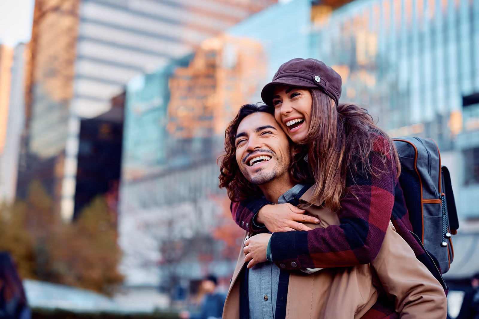 Young couple laughing together outdoors, representing whole-person mental health care