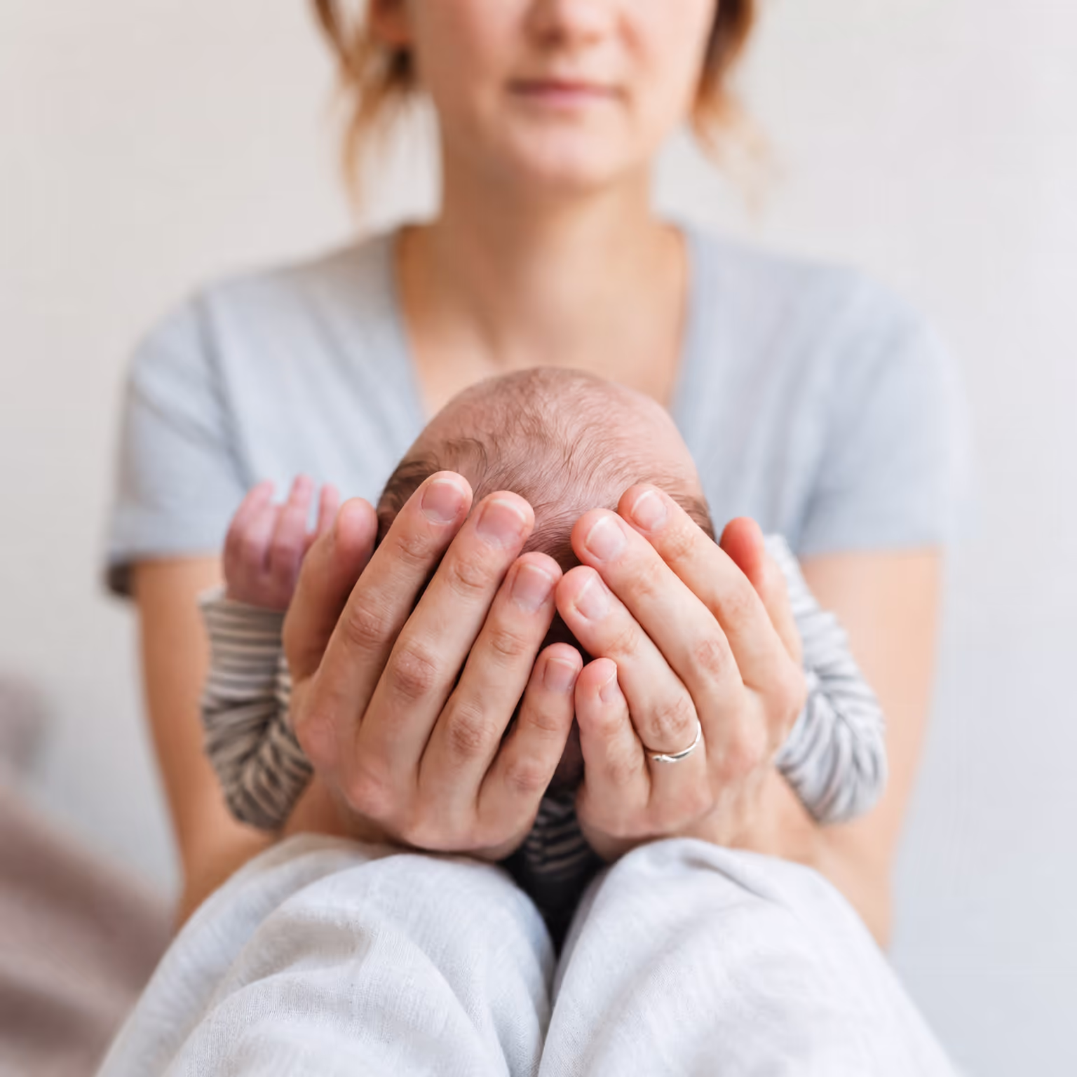 New mother gently holding her newborn baby close