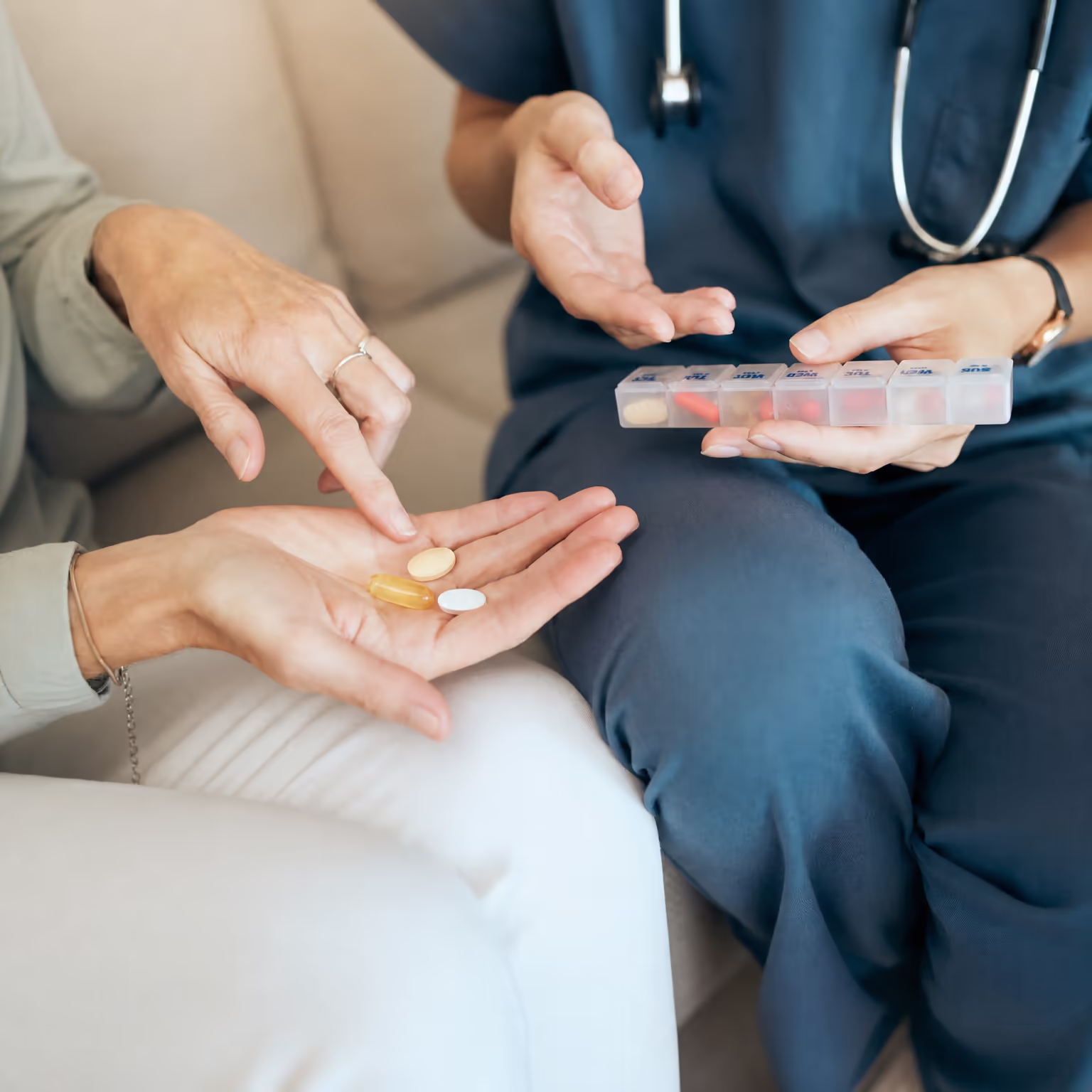 Clinician and patient reviewing medications with a weekly pill organizer